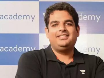 Person in front of Unacademy banner